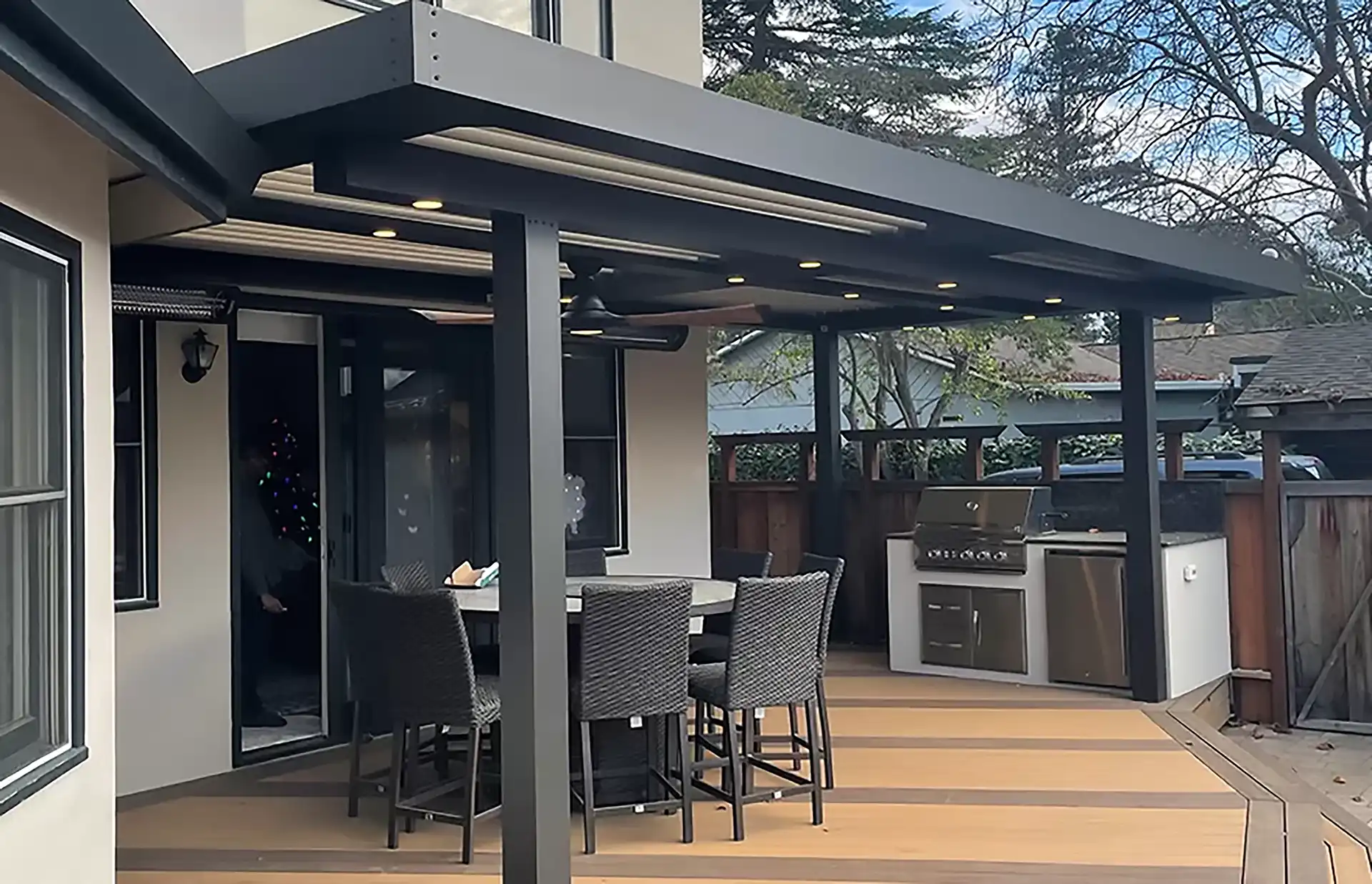 Struxure pergola providing cover for deck and outdoor kitchen