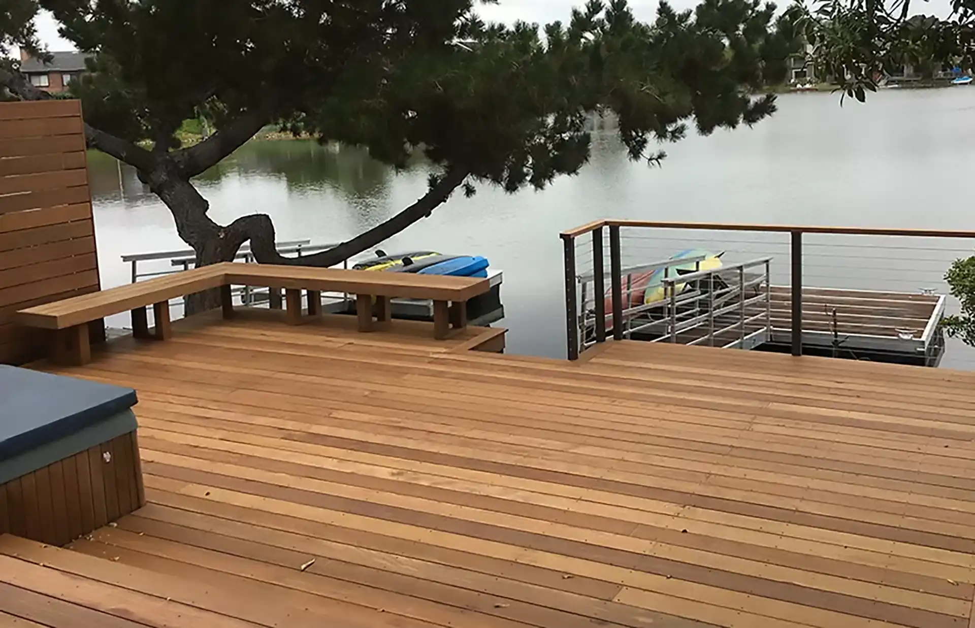 multi-level waterfront deck with deck railing and built-in benches.
